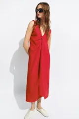 Vestido midi de Zara Woman Collection color rojo, confeccionado con mezcla de lino. Presenta escote en V pronunciado, mangas sisa y un diseño con frunce delantero y detalle drapeado. Cuenta con bajo recto y cierre lateral con cremallera oculta.