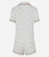 Pijama corto de dos piezas confeccionado en viscolycra blanca con estampado floral y vivo en contraste. Incluye una camisa de manga corta con cuello solapa y cierre frontal de botones, y un short con cintura elástica.