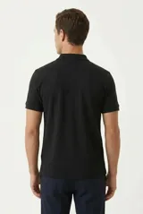 Remera polo de manga corta color negro, confeccionada en 100% algodón, con cuello clásico y cierre frontal de tres botones.