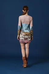 Vestido corto de manga larga con escote en V, caracterizado por un estampado artístico que representa un paisaje montañoso con ciervos en la parte inferior.