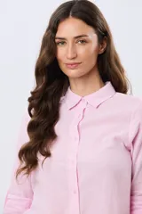 Camisa de lino lisa de manga larga, con cuello clásico y cierre frontal de botones.
