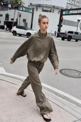 Pantalón de tiro alto con pernera recta, cintura elástica en la parte posterior y nervio marcado en el frente. Cuenta con cierre frontal de botón y ganchos, bolsillos delanteros y bolsillos de plastrón en la parte trasera.