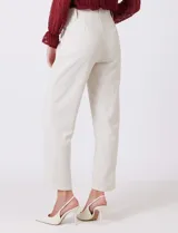 Pantalón sastrero color beige, de corte recto y tiro alto, con largo al tobillo. Tiene pretina limpia con cierre interno y pasadores, y bolsillos funcionales en la parte delantera.