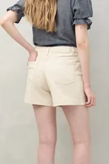 Short de algodón color beige, con diseño clásico de cinco bolsillos, tiro medio y terminación recta.