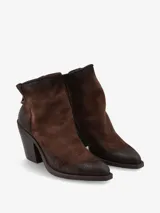 Bota corta de gamuza con estampado animal print de leopardo en tonos marrones y negros. Presenta un taco cuadrado alto y cierre posterior con tirador metálico.