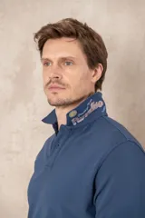Chomba azul de piqué de algodón con cuello polo, tapeta de dos botones con diseño estampado en el interior y mangas cortas. Corte clásico.