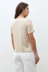 Remera de manga corta color beige melange, con cuello redondo y corte recto.