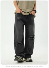 Jean de corte ancho y holgado, color negro lavado con efecto desgastado y roturas visibles en la parte delantera de las piernas. Presenta cinco bolsillos.