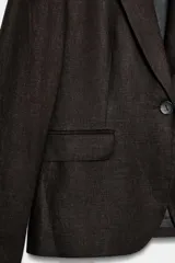 Blazer de cuello solapa y manga larga, con cierre frontal de un botón y bolsillos laterales con solapa. Confeccionado en tejido con mezcla de lino.