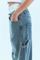 Pantalón de jean azul claro de corte holgado, tiro bajo y presillas anchas.