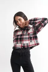 Buzo crop de corderito con estampado a cuadros en blanco, negro y rojo, con cierre de cremallera en el cuello.