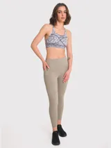 Calza deportiva de tiro alto color beige, con bolsillos laterales y banda de silicona interna para mejor ajuste. Confeccionada en tejido técnico elástico.