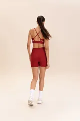 Top deportivo color ladrillo con tirantes finos cruzados en la espalda, escote redondo y almohadillas removibles.