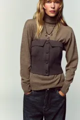 Top bustier corsetero color gris oscuro, con escote recto, solapa y hombros descubiertos. Presenta falsos botones forrados a tono en el frente y cierre lateral con cremallera oculta.