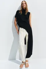 Jeans de tiro medio con corte tapered, diseño de cinco bolsillos y cierre frontal con cremallera y botón. Presenta un estampado de rayas verticales a contraste en tonos claros.