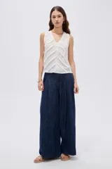 Musculosa blanca de poliéster con cuello en V, tirantes anchos y diseño holgado con franjas horizontales en chevron en el frente.