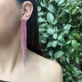 Aros largos con base rígida y flecos de strass color rosa.