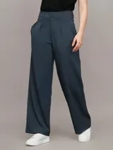 Pantalón de vestir azul petróleo, de corte sastre y pierna ancha. Presenta bolsillos laterales, cierre con clip y cremallera. Confeccionado en poliéster reciclado, ecovero viscosa y elastano.