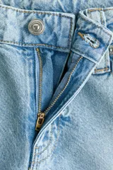 Jean baggy de tiro bajo en denim de algodón rígido, con piernas amplias y diseño de cinco bolsillos.