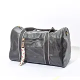 Bolso tipo duffel negro con textura símil cuero, doble asa de mano y correa al hombro regulable.