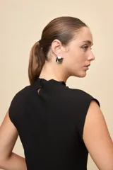 Top de calce entallado, sin mangas y con cuello alto, confeccionado en tejido texturado de líneas simples.
