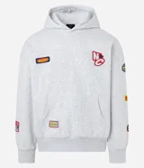 Buzo tipo hoodie con corte boxy, confeccionado en algodón con fondo melange. Presenta capucha, bolsillo canguro frontal, puños y ruedo acanalados, y múltiples parches bordados decorativos en el frente y las mangas.
