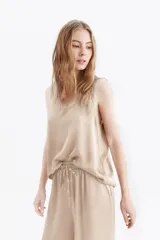 Musculosa de satén con escote redondo y corte holgado, ideal para un look sofisticado y ligero.