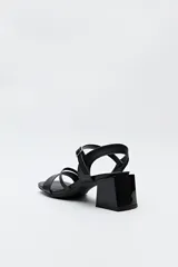 Sandalias doradas con tiras finas, pulsera regulable al tobillo y taco geométrico medio.