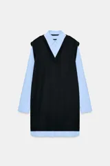Vestido corto que combina una camisa celeste de manga larga con cuello solapa y botones frontales, con un chaleco de tejido negro sin mangas y escote en V superpuesto.