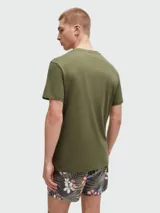Remera de algodón color verde oliva, con cuello redondo, mangas cortas y logo de la marca estampado en el frente en color blanco.