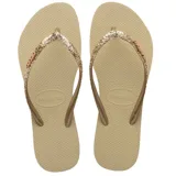 Sandalias tipo ojota Havaianas modelo Slim Glitter II, color beige arena. Presentan tiras finas con acabado de glitter brillante y logo de la marca en relieve.