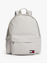 Mochila de diseño redondeado en color gris claro, confeccionada en poliéster texturizado. Cuenta con un compartimento principal con cierre, un bolsillo exterior con cremallera en la parte frontal y un bolsillo interior de malla abierto. Posee asa superior y correas ajustables y acolchadas. Lleva un parche tejido de Tommy Jeans en la parte delantera.