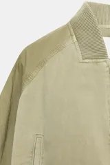 Chaqueta bomber de cuello redondo y manga larga con efecto lavado. Presenta bolsillos de vivo en el delantero, cierre frontal con cremallera y acabados en rib en cuello, puños y bajo.