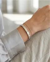 Esclava rígida de acero con acabado pulido brillante y diseño minimalista.