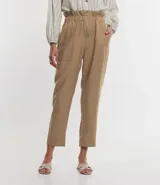 Pantalón carrot color beige confeccionado en viscosa, con cierre delantero en cremallera y cintura elástica.