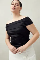 Top negro con escote off-shoulder, de tejido de punto con efecto satinado y corte ajustado.