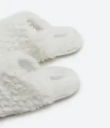 Pantufla cerrada de mujer con textura de peluche suave en color negro, diseñada para brindar comodidad en el hogar.