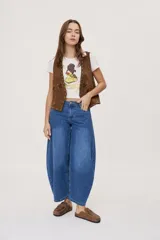 Jean de tiro medio y corte barrel con pierna amplia y ligeramente curva, estilo de cinco bolsillos en denim negro lavado.