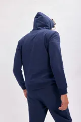 Canguro deportivo de color azul marino, con capucha ajustable mediante cordones y bolsillo frontal tipo canguro. Presenta puños y ruedo acanalados para un mejor ajuste.