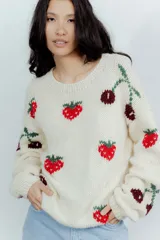 Buzo de lana merino color crema con diseño tejido de frutillas y cerezas en tonos rojos y bordó. Presenta cuello redondo, mangas largas y un corte holgado.