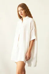 Camisa de corte oversize y diseño holgado, confeccionada en tela de viscosa texturizada. Presenta cuello clásico, cierre frontal con botones de carey y mangas cortas con dobladillo.