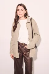 Sobrecamisa color beige de algodón peinado, corte recto, con cuello camisero, cierre frontal con botones y bolsillos de parche en el pecho.