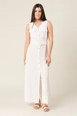 Vestido camisero largo sin mangas color negro, con cuello en V y cierre de botones delanteros. Incluye cinturón ancho a tono y bolsillos estilo safari en el pecho.