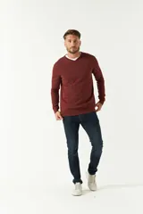 Sweater de punto color negro con escote en V, manga larga y puños acanalados. Presenta un pequeño logo bordado en el pecho.
