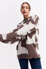 Sweater de punto con diseño abstracto bicolor en tonos marrón y blanco, de silueta amplia y relajada, con cuello redondo y mangas largas.