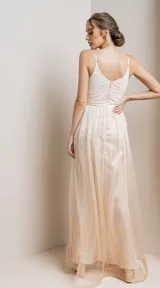 Vestido largo de fiesta con escote en V cruzado y breteles finos. Confeccionado en tela con acabado brillante y falda con caída fluida.