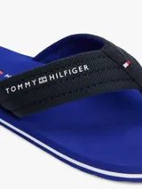 Ojotas Tommy Hilfiger con base azul y tiras de tela trenzada azul marino con logo de la marca en blanco.