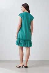 Vestido corto de color rojo con cuello en V, mangas cortas integradas y un detalle de volado en el ruedo. Presenta un diseño de silueta holgada y minimalista.