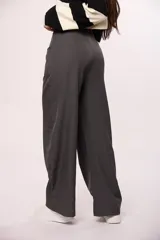 Pantalón sastrero de corte amplio y tiro alto, con bolsillos laterales y cierre frontal con botón.
