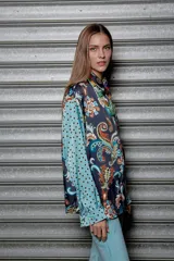 Camisa holgada estampada con motivos paisley en tonos marrón, beige y azul. Tiene cuello solapa, mangas largas y cierre frontal con botones.